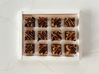 Row of french chocolate fondant cake in a white box on a light marble background