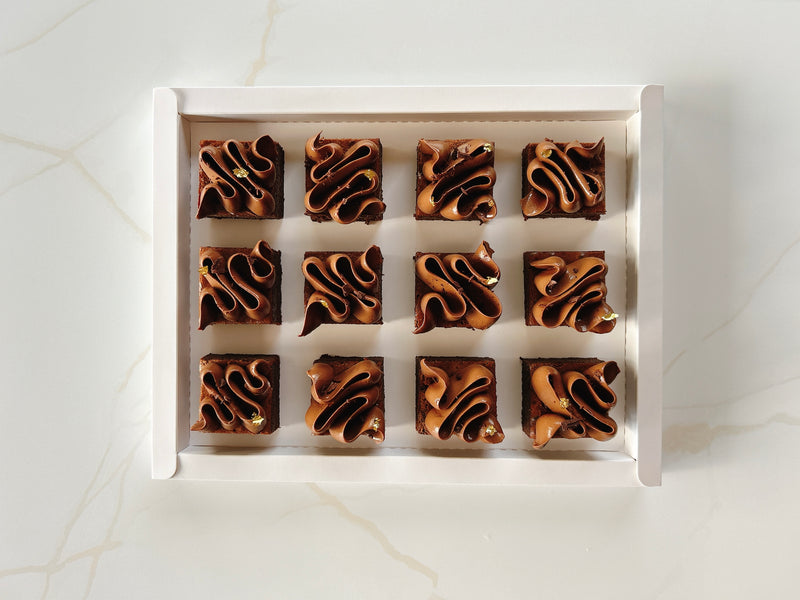 Row of french chocolate fondant cake in a white box on a light marble background