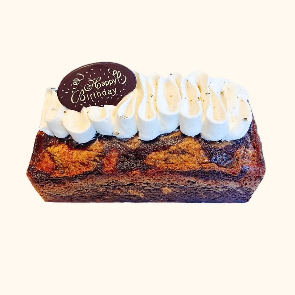 Marbled cake with white frosting and a 'Happy Birthday' topper on a white background