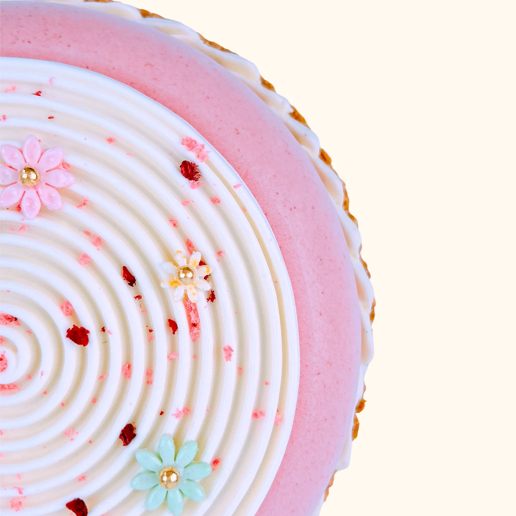 Close-up of a pink and white french cake newvastle with decorative flowers on a light background