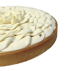 Close-up of a French lemon tart featuring smooth vanilla whipped cream piped into elegant petals and a buttery pastry crust.