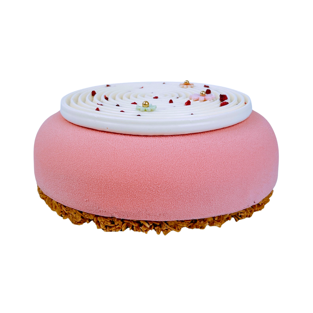 Elegant Red Berry & Coconut French entremet with a pink velvet finish, white coconut spiral décor, pastel sugar flowers and freeze-dried raspberries for celebrations.